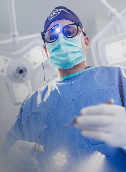 Surgeon performing a procedure in an operating room.